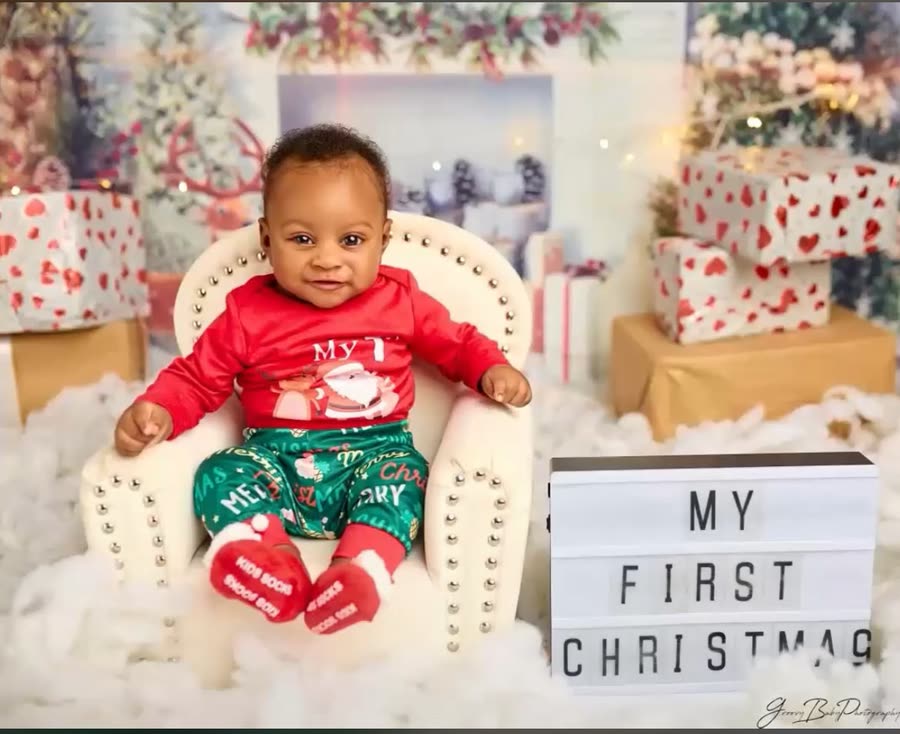 A baby in a red outfit at a 'My First Christmas' photoshoot