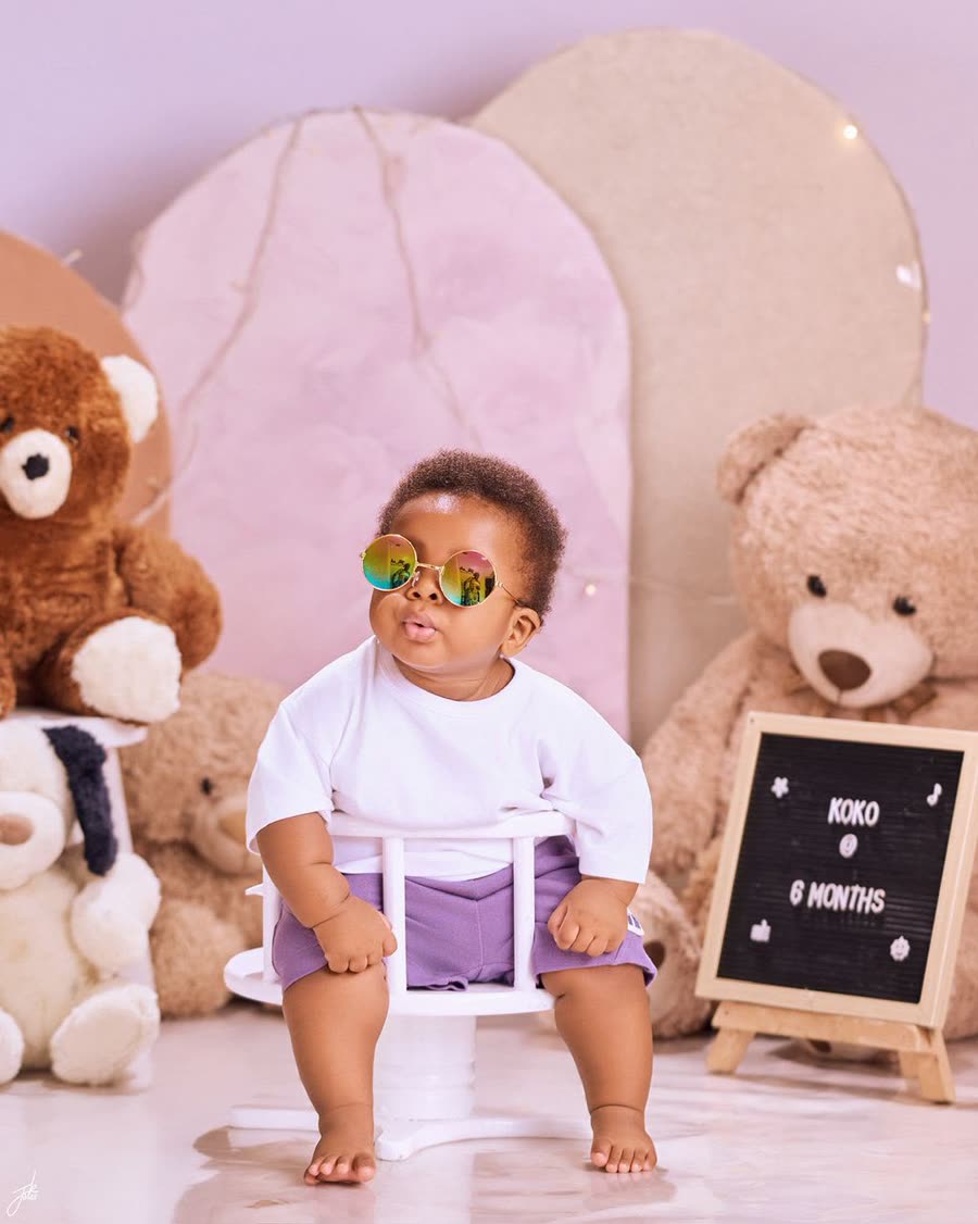 A baby in sunglasses at an eight-month milestone photoshoot