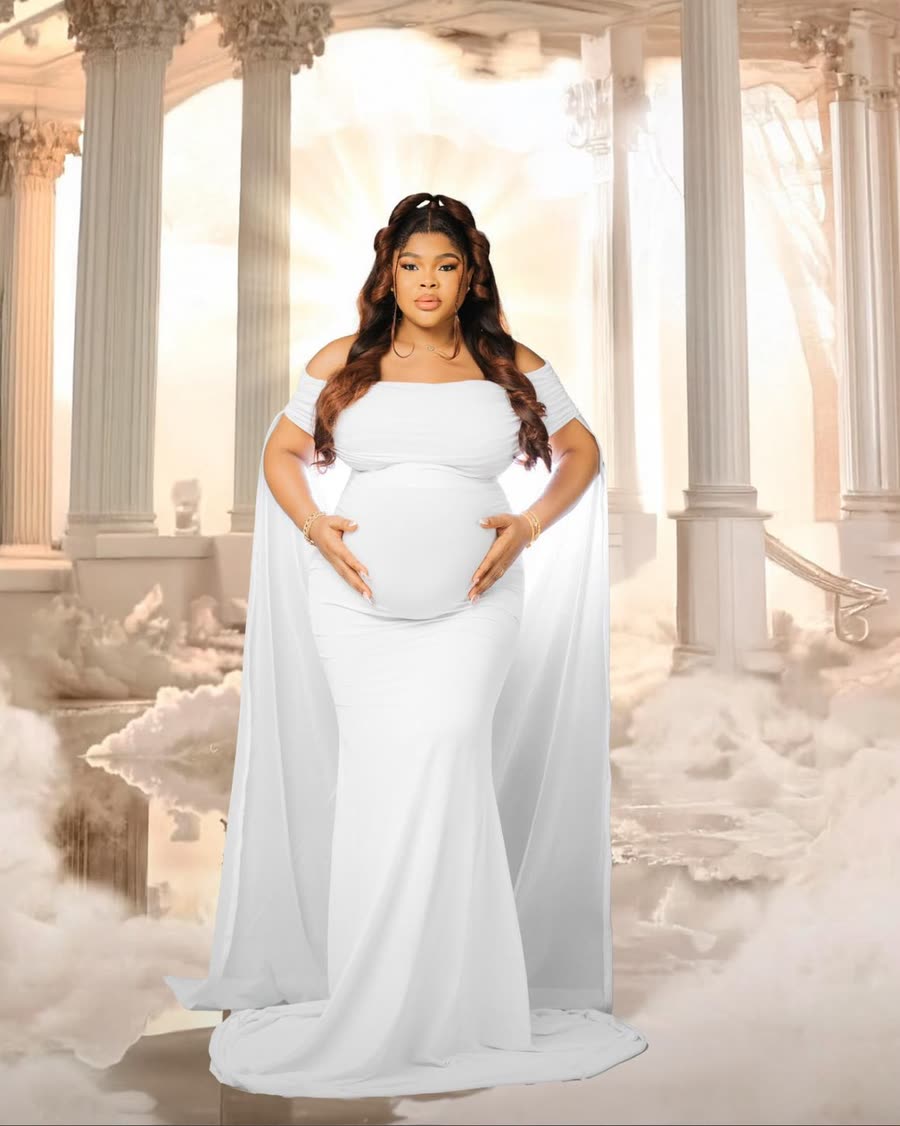 An expectant mother in a flowing white maternity gown